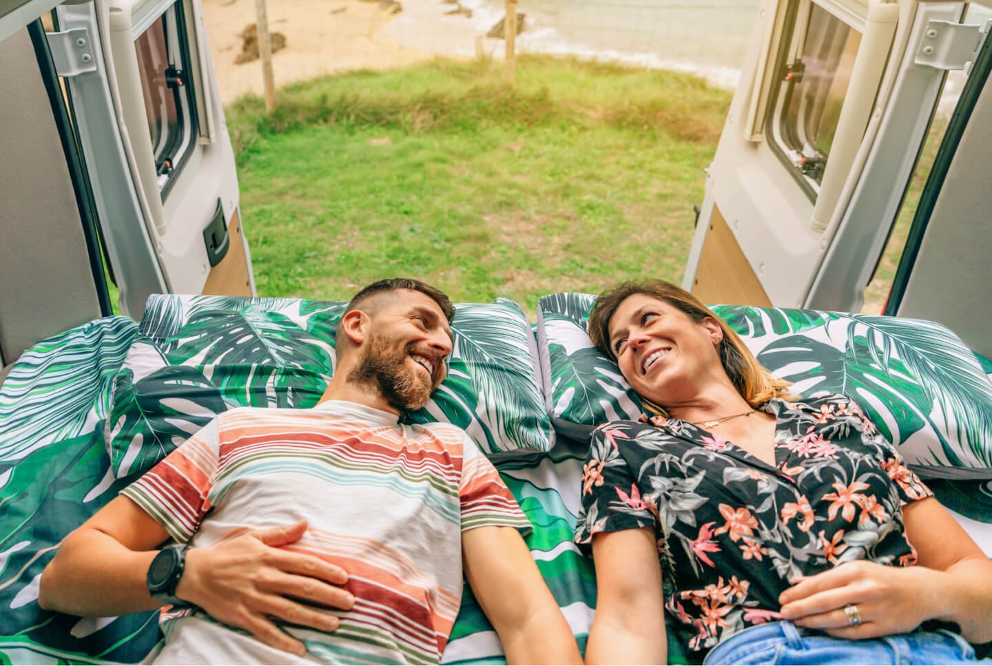 Couple installé sur le couchage d'un van aménagé