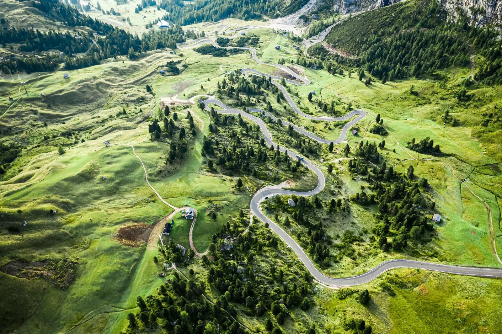 Route de col alpin entre alpages et sommets, passage vers l'Italie en van aménagé