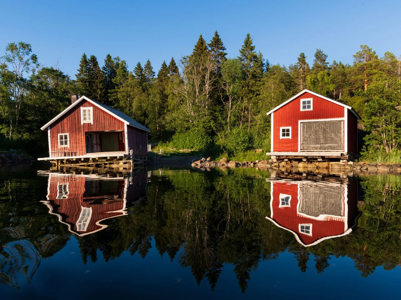 Maisons de bois rouges au bord d'un lac de Dalécarlie en Suède